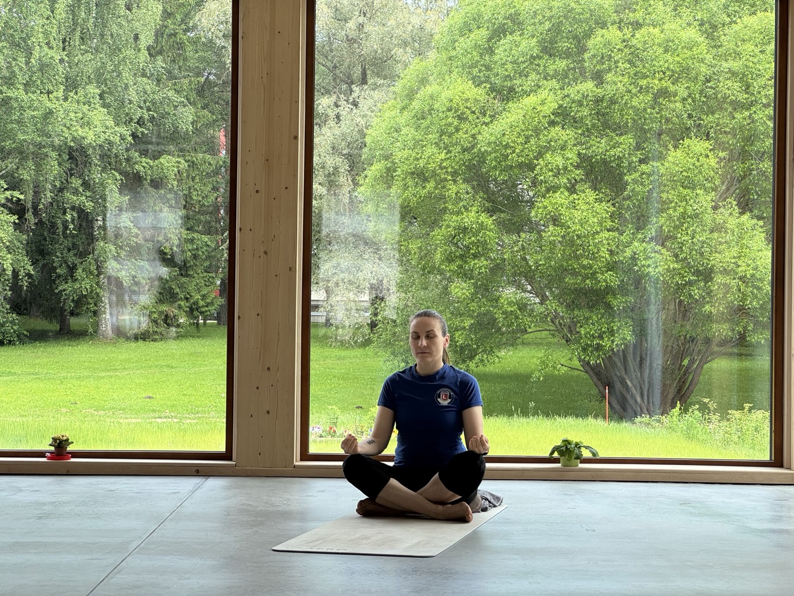 Kristina meditating by the studio windows overlooking the garden in Elva, Estonia
